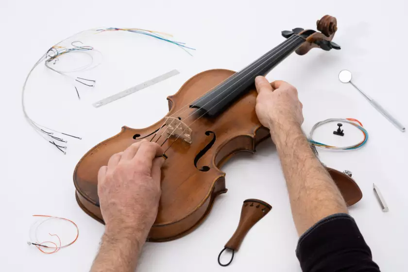 Photographie de reportage réalisée par Bertrand Perret montrant Jens Rossbach intervenant sur le réglage d'un violon.