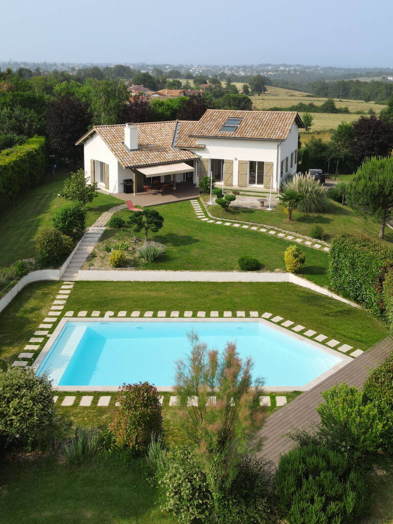Photographie aérienne réalisée avec un drone pour mettre en valeur une villa et sa piscine pour l'entreprise DEL