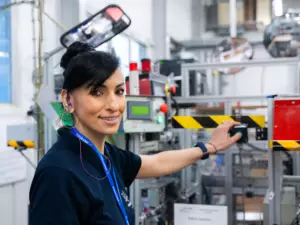 Photographie de reportage réalisée par Bertrand Perret montrant une salariée de l'entreprise Thuasne activant le bouton d'une machine