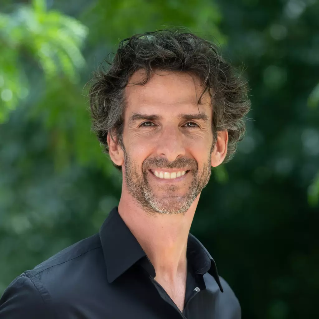 Portrait de Bertrand Perret avec une chemise noire, en 2026, face à l'objectif. Photo servant à illustrer le site internet