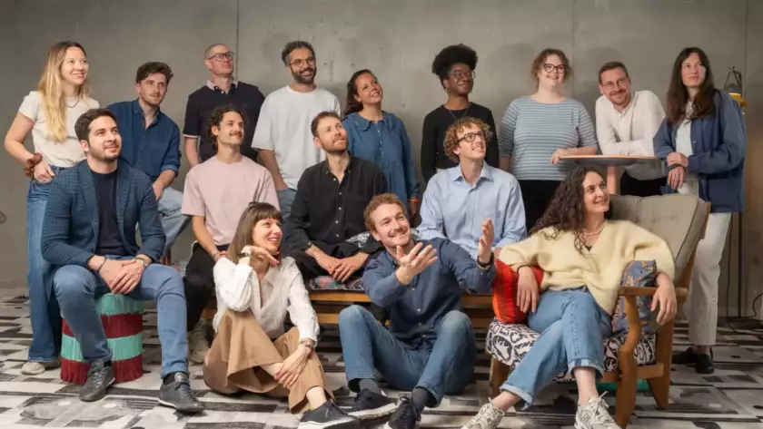 Photo d'équipe joyeuse avec des personnes assises et debout
