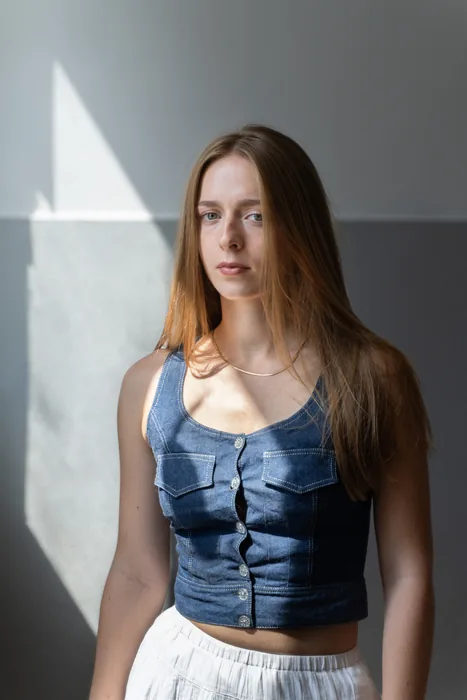 Photographie d'une jeune femme en lumière naturelle dans un environnement existant (une cage d'escalier avec un mur bicolore)