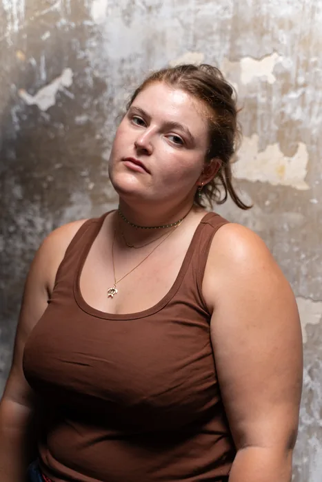 Portrait d'une jeune femme en lumière naturelle mixte (avec flash) dans un environnement réél (mur décrépi)